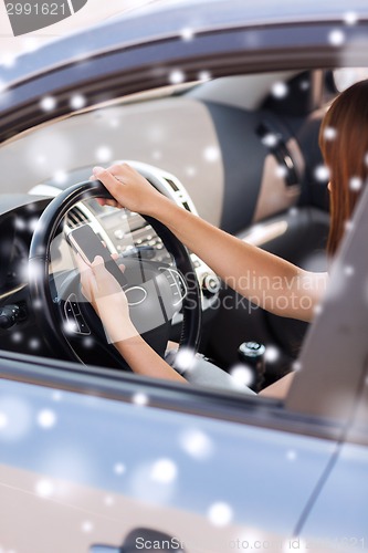Image of close up of woman with  smartphone driving car