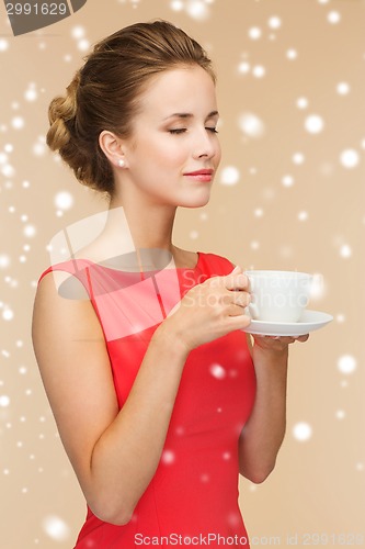 Image of smiling woman in red dress with cup of coffee