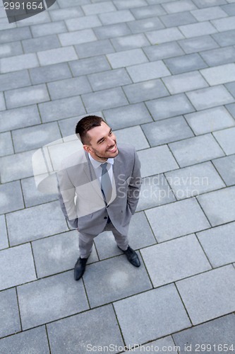 Image of young smiling businessman outdoors from top