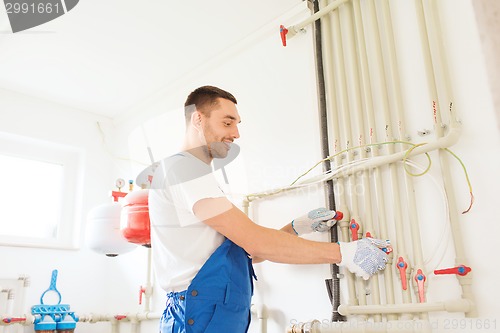 Image of smiling builder or plumber working indoors