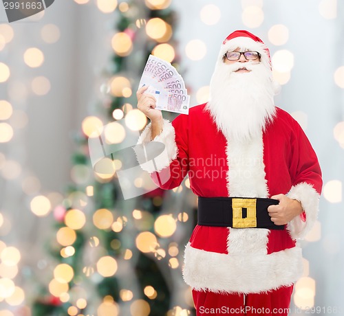 Image of man in costume of santa claus with euro money