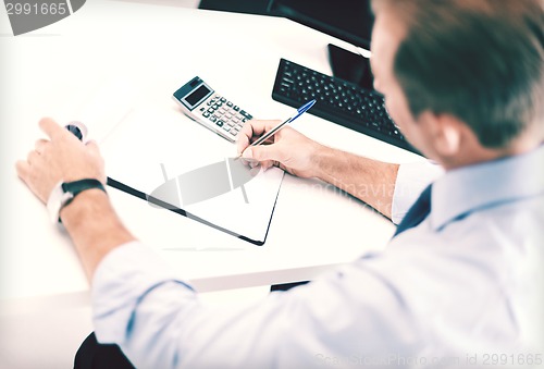 Image of businessman with notebook and calculator