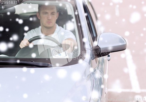 Image of man driving car and putting parking clock