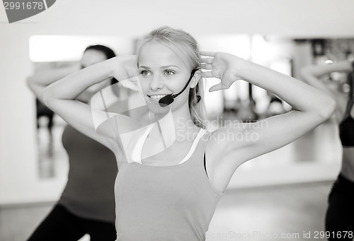 Image of group of smiling people exercising in the gym