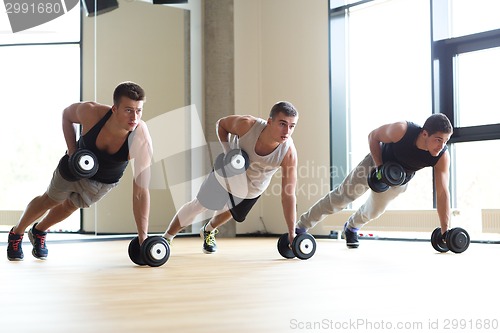 Image of group of men with dumbbells in gym