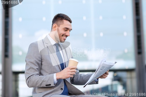 Image of young businessman with coffee and newspaper