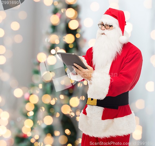 Image of man in costume of santa claus with tablet pc