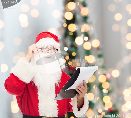 Image of man in costume of santa claus with notepad