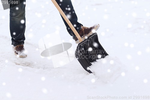 Image of closeup of man digging snow with shovel