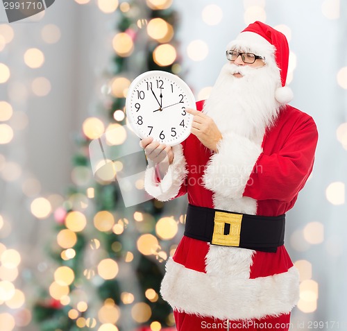 Image of man in costume of santa claus with clock