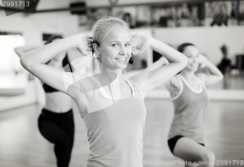 Image of group of smiling people exercising in the gym