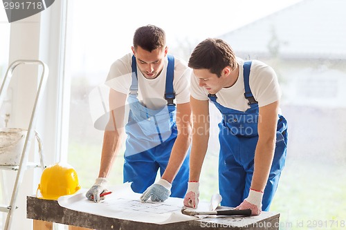 Image of group of builders with blueprint