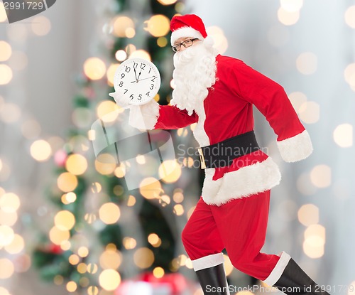 Image of man in costume of santa claus with clock