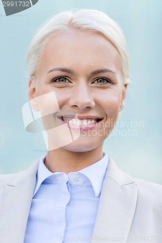 Image of young smiling businesswoman over office building