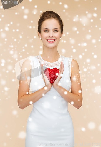 Image of smiling woman in white dress with red heart