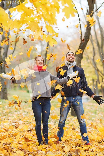 Image of smiling couple having fun in autumn park