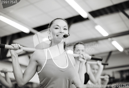 Image of group of smiling people working out with barbells