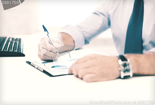 Image of businessman working and signing papers