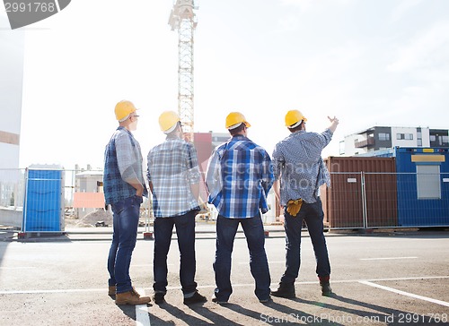 Image of group of builders in hardhats outdoors