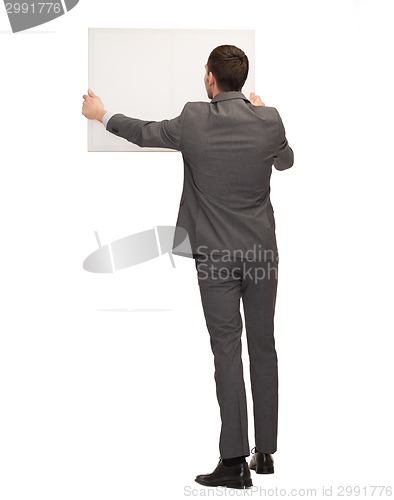 Image of businessman or teacher with white board from back