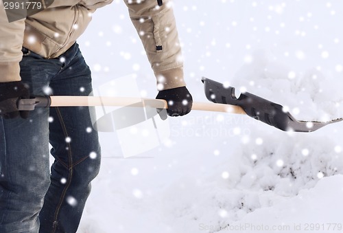 Image of closeup of man digging snow with shovel