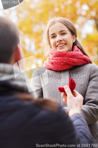 Image of close up of couple with engagement ring in box