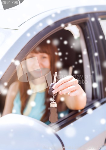Image of close up of smiling woman with car key outdoors