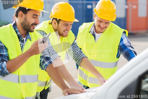 Image of group of smiling builders in hardhats outdoors