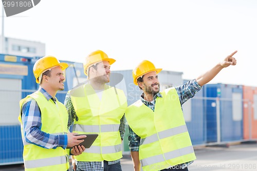 Image of smiling builders in hardhats with tablet pc