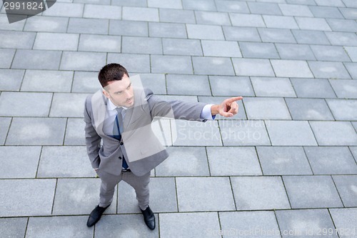 Image of young smiling businessman outdoors from top