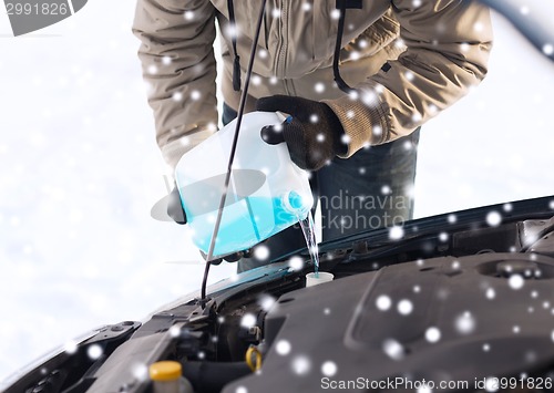 Image of closeup of man pouring antifreeze into car