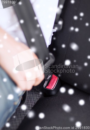 Image of close up of man fastening seat belt in car