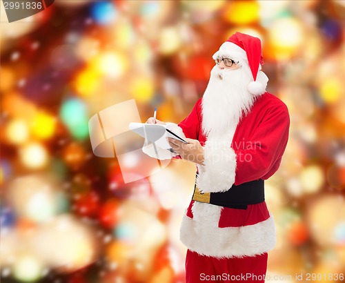 Image of man in costume of santa claus with notepad