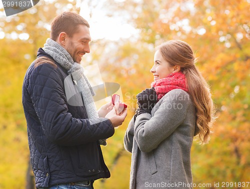 Image of smiling couple with engagement ring in gift box