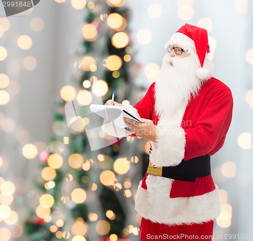 Image of man in costume of santa claus with notepad