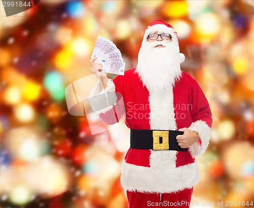 Image of man in costume of santa claus with euro money