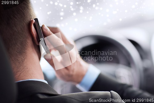 Image of close up of man using smartphone while driving car