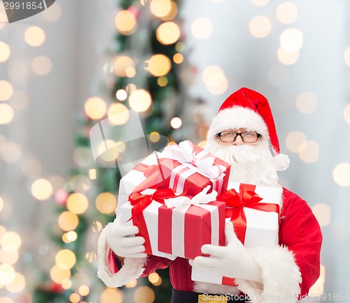 Image of man in costume of santa claus with gift boxes