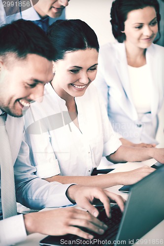 Image of group of people working with laptops in office