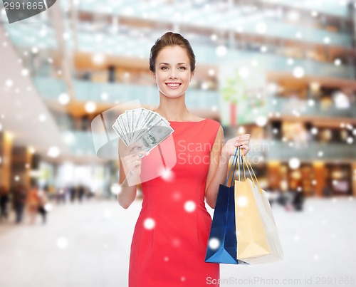 Image of smiling elegant woman in dress with shopping bags