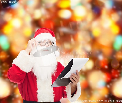 Image of man in costume of santa claus with notepad