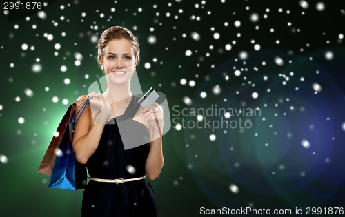 Image of smiling woman with shopping bags and credit card