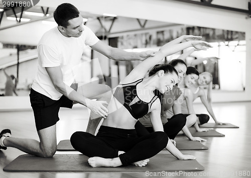 Image of group of smiling women stretching in the gym