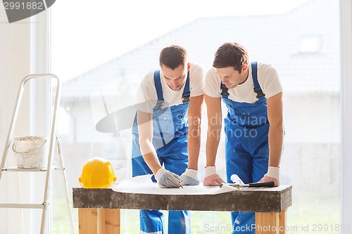 Image of group of builders with blueprint