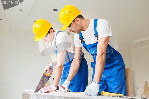 Image of group of builders with tools indoors