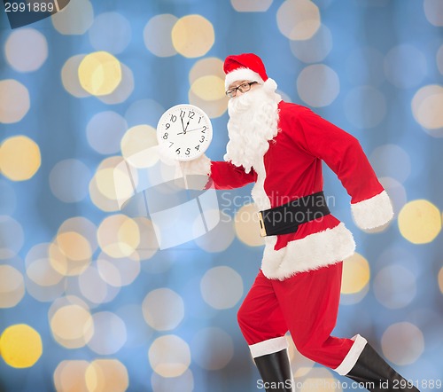 Image of man in costume of santa claus with clock