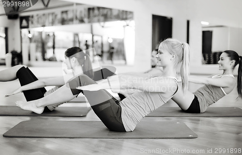 Image of group of smiling women exercising in the gym