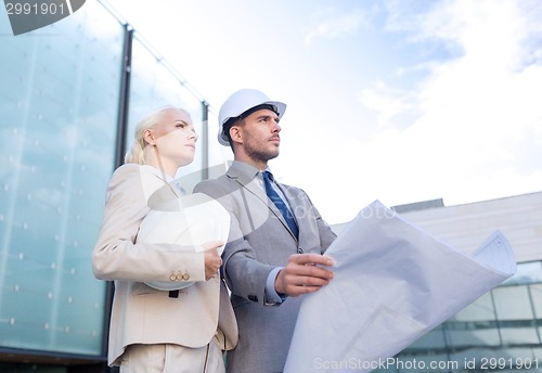 Image of businessmen with blueprint and helmets