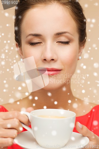 Image of smiling woman in red dress with cup of coffee