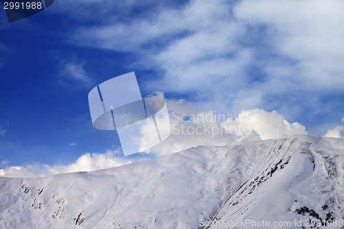 Image of Off-piste slope at evening and sky with clouds